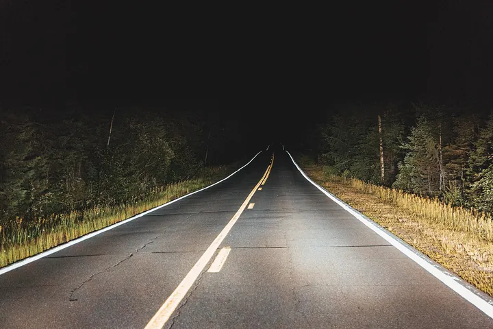 夜の道路をライトが照らす