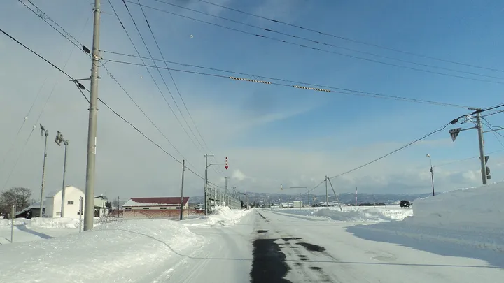 冬の北海道の道と矢羽根の標識