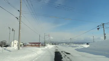 冬の北海道の道と矢羽根の標識