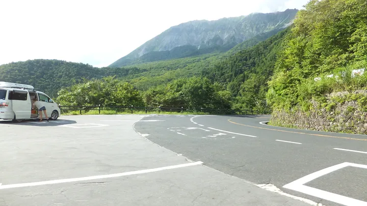 大山の見える山道と車