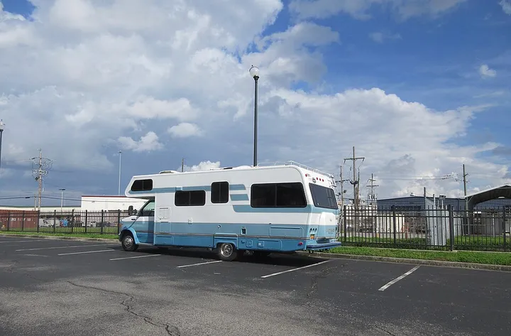 駐車場に停まった白と水色のキャンピングカー