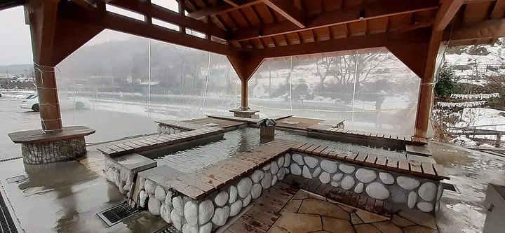 雪景色の足湯の屋根付き湯船