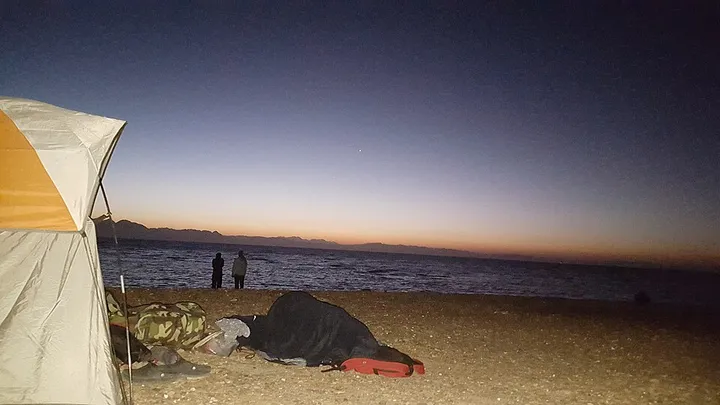 夕暮れの浜辺のテントと寝袋