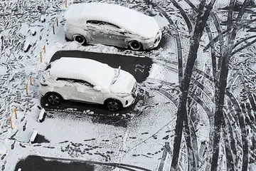 雪をかぶった駐車場の車