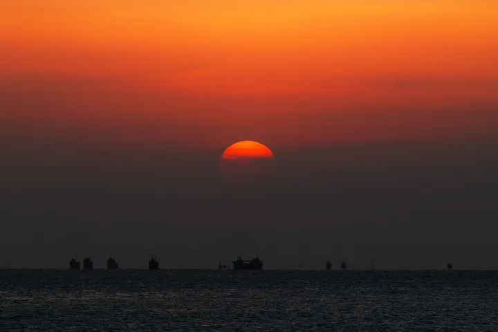 海に沈む夕日と行き交う船
