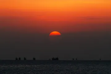 海に沈む夕日と行き交う船